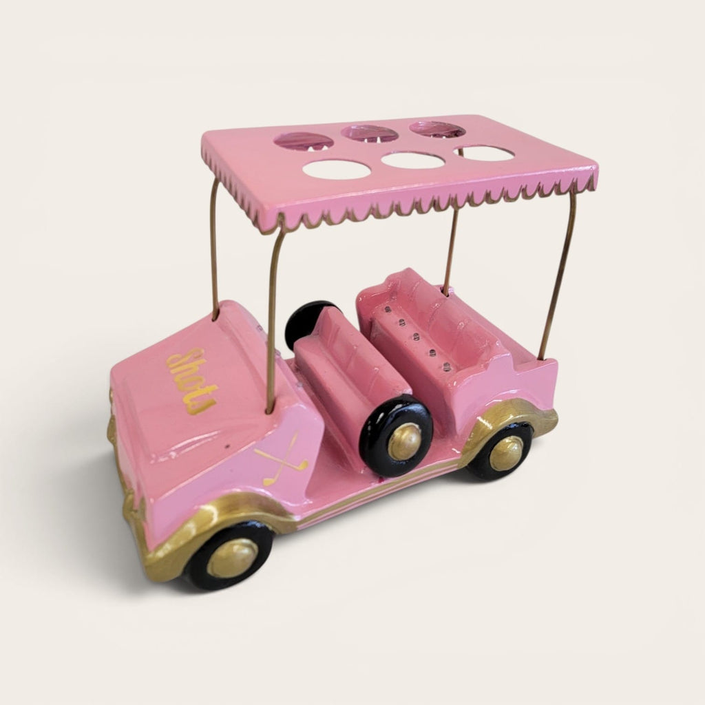 A pink metal golf cart toy with gold trim, black wheels, and a matching pink canopy with cup holders, shown on a plain light background.