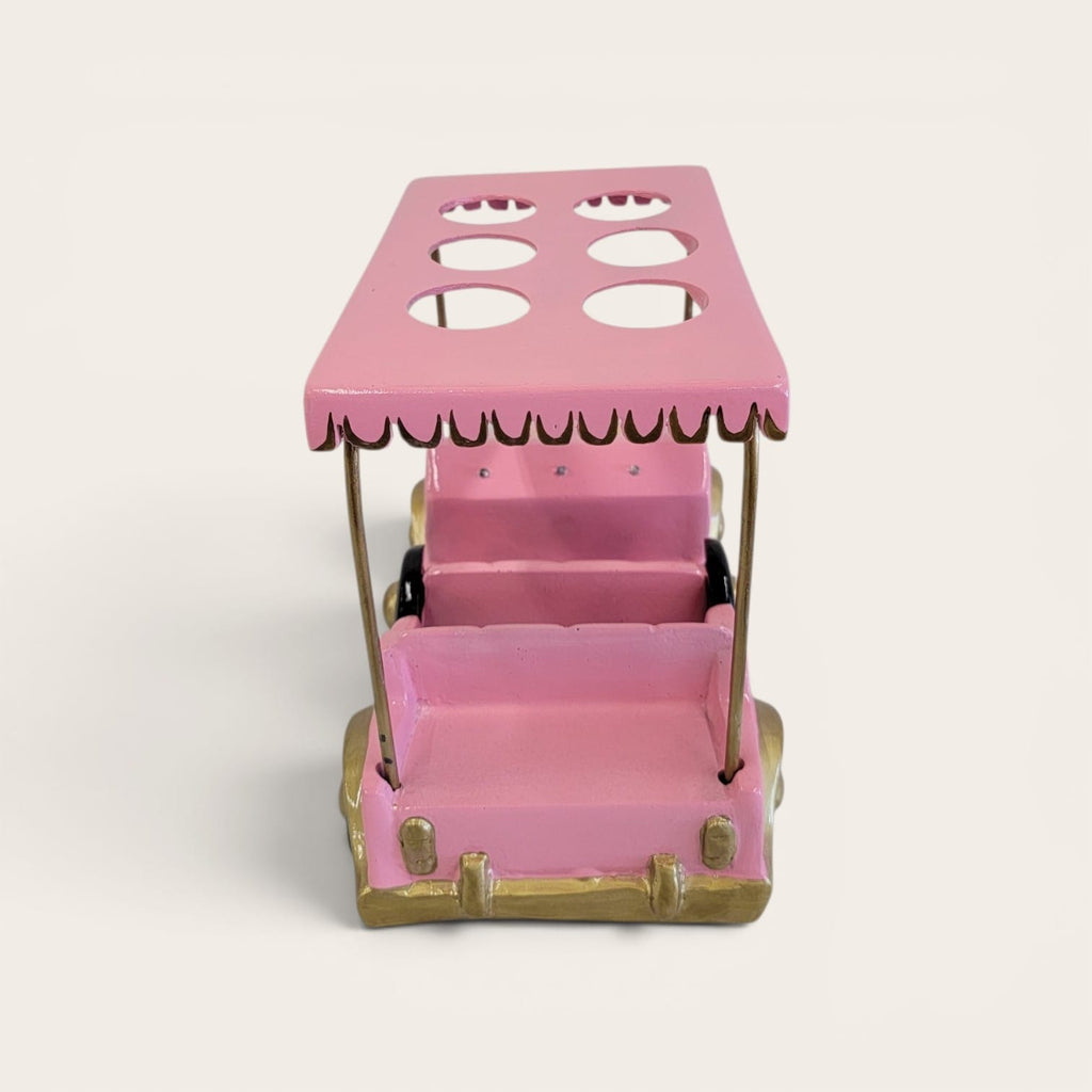 A pink miniature golf cart or ride-on toy with gold-colored wheels and trim, photographed on a clean, light off-white background.