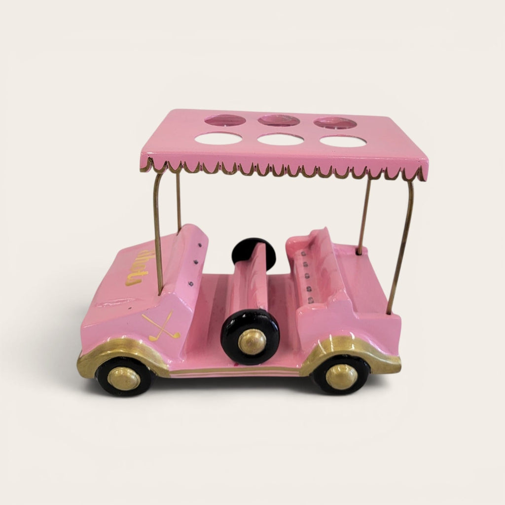 A pink and gold toy golf cart with a matching canopy top featuring circular cutouts, set against a solid off-white background.